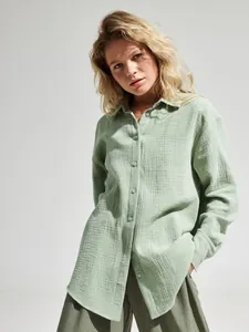 Dettaglio camicia da donna in cotone stropicciato verde chiaro vestibilità ampia