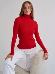 Nahaufnahme eines hochwertigen, leuchtend roten Rollkragenpullovers aus Rippstrick für Damen