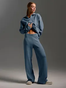 Detail view of stylish two-piece blue knitted polo sweater and wide-leg trousers set on model