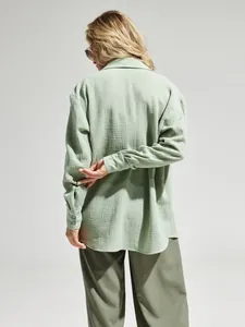 Vista posteriore di una camicia oversize in cotone stropicciato verde salvia.