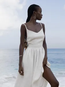 Elegant white pure cotton V-neck backless camisole dress shown on a beach
