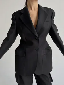 Primo piano di un blazer nero sfiancato da donna con una silhouette molto definita.