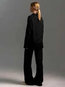 Back view of black Polo neck knitted sweater and wide-leg trousers set for women.
