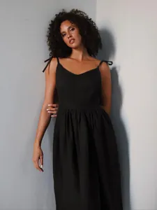 Close-up of elegant black V-neck cotton midi dress with tie-shoulder straps.