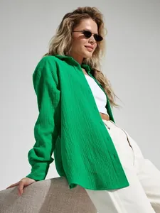 Dettaglio camicia da donna ampia in cotone stropicciato verde per un look estivo