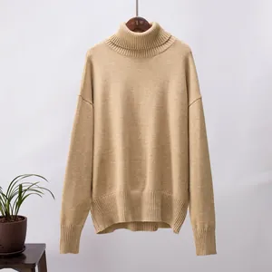 Nahaufnahme eines khakifarbenen Oversize-Rollkragenpullovers mit Rippbündchen am Saum.