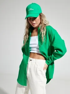 Vista dettagliata della camicia larga in crespo di cotone verde da donna con trama fine.