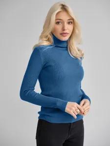 Detailansicht des blauen Rollkragenpullovers mit Rippstrick an einem blonden Model.