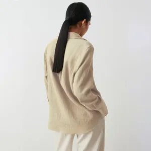 Vista posteriore dettagliata di una camicia in cotone beige rilassata con texture