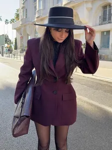 Dettaglio di un elegante blazer bordeaux sciancrato da donna in un contesto street style