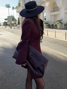 Dettaglio di un elegante blazer bordeaux con scollo a V e pochette coordinata chic.