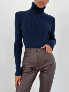 Detail eines dunkelblauen Rollkragenpullovers kombiniert mit brauner Kunstlederhose