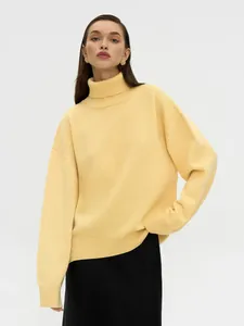 Eleganter hellgelber lockerer Strickrollkragenpullover für Damen am Modell präsentiert