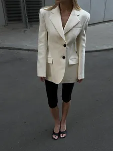 Vista completa di un blazer avvitato crema con bottoni neri per un look da ufficio chic