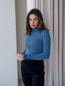 Close-up of a stylish blue ribbed knit mock-neck sweater for women in a slim fit design.