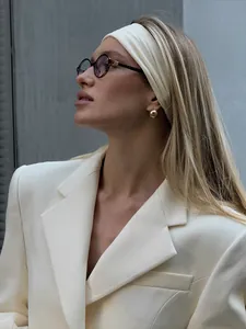 Dettaglio di un blazer bianco sfiancato su una modella per un look da ufficio elegante.