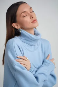 Eleganter hellblauer Oversize-Rollkragenpullover für Damen, Close-up Lookbook-Foto.