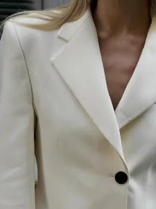 Primo piano dettagliato del colletto di un blazer bianco slim fit con bottone nero
