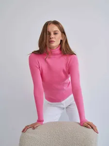 Nahaufnahme des rosa Rollkragenpullovers mit feiner Rippenstruktur und Passform