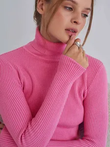 Detailaufnahme eines rosa gerippten Rollkragenpullovers, getragen von einem Model