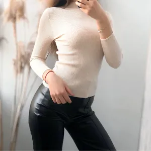 Detailed view of beige ribbed knit turtleneck sweater showing slim fit and soft fabric