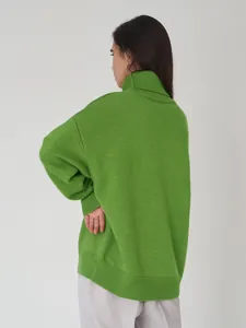 Rückansicht des eleganten, grünen Oversize-Rollkragenpullovers für Herbst und Winter.