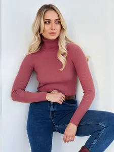 Detailaufnahme einer Frau in einem rosa gerippten Rollkragenpullover und blauen Jeans