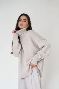 Nahaufnahme eines eleganten, übergroßen beigen Rollkragenpullovers für Damen
