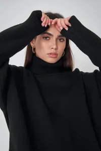 Nahaufnahme eines eleganten schwarzen Rollkragenpullovers mit Strickstruktur.