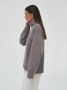 Seitenansicht eines eleganten grauen Oversize-Rollkragenpullovers für Damen im Winter