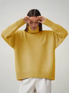 Detailaufnahme eines senfgelben Oversize-Rollkragenpullovers mit Rippbündchen