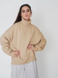 Detailaufnahme eines beigefarbenen Oversize-Rollkragenpullovers mit hochwertiger Strickstruktur