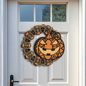 Detailed view of a laser-cut wooden Halloween pumpkin wreath hanging on a white door