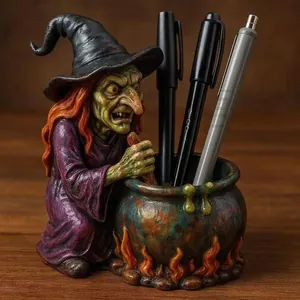 Detailed view of a spooky resin witch stirring a cauldron pen holder on a wooden desk