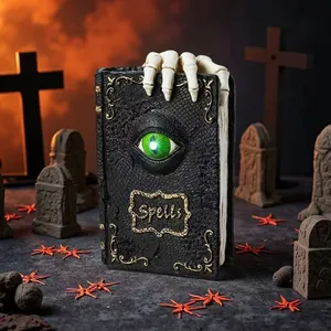Detailed view of Halloween resin spell book with skeleton hand and glowing eye