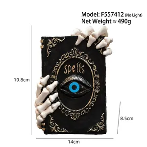 Detailed view of Halloween resin magic book ornament with skeleton hands, 19.8cm height.