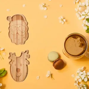 Top view of Santa and reindeer shaped wooden trays served with macarons and coffee