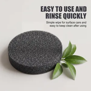 High-quality close-up of a black textured cleaning sponge for pots with green leaves