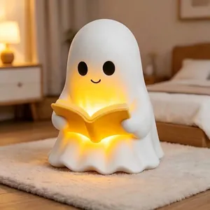 Close-up of a cute white ghost reading lamp with warm yellow light in a bedroom