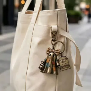 Detailed close-up of a rustic Halloween ghost keychain with patches on a tote bag
