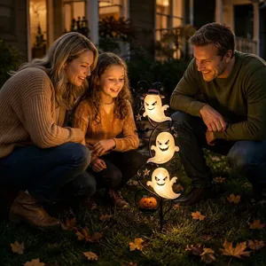 Happy family admiring glowing solar Halloween ghost garden stake lights at night