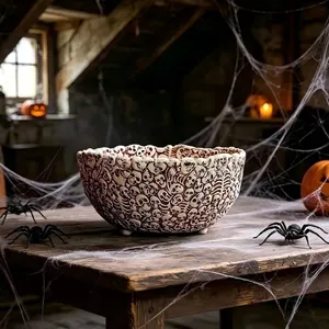 Detailed view of Halloween resin bowl with skull relief patterns on a rustic table