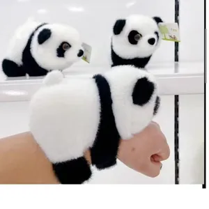 Detalle de una pulsera de panda de peluche realista en la muñeca mostrando la textura del pelaje