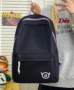 Detail showing the front of the black backpack with purple accents and M logo