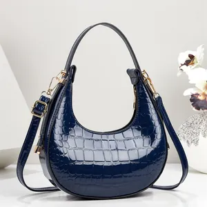 Stilvolle marineblaue Halbmondtasche mit Krokoprägung in luxuriösem Studiodesign