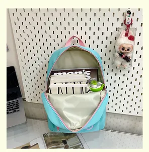 Internal compartment detail of light blue school backpack showing large storage capacity
