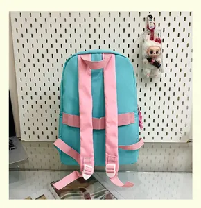 Detail view of the back and pink straps of a teal lightweight student school backpack.