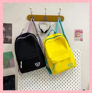Minimalist black and yellow school backpacks with large capacity, hanging on wall hooks