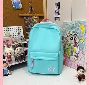 Contextual view of a mint blue schoolbag on a desk with cute student decorations.