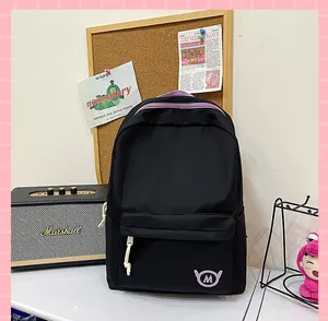 Stylish black high-capacity student backpack with purple accents in a cozy study room setting